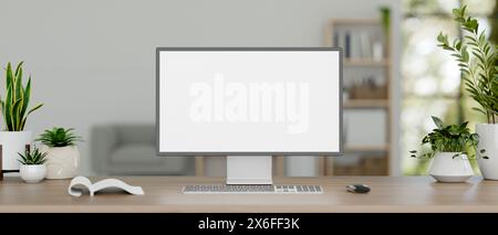 A front view of a white-screen desktop computer mockup and decor plants on a wooden desk in a minimal white office room. private office, home office w Stock Photo