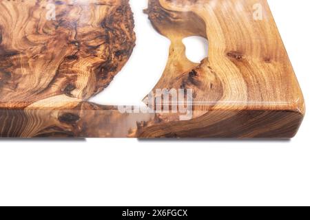 Live edge elm burl slab table top with central epoxy resin river on white background, combining natural wood with a synthetic material close view Stock Photo
