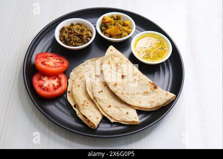 Roti and bhaji. Indian vegetarian Thali or platter includes akhha Masoor sabzi, dal, fansi or beans ki sabji, and chapati. Indian food. Stock Photo