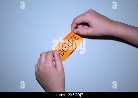 Top view image of hand tearing  piece of paper and change the word from DISLIKE to LIKE. Changing opinion concept. Stock Photo