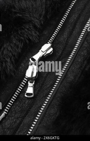 Double metal zipper on a black sheepskin coat from Shearling background close up Stock Photo