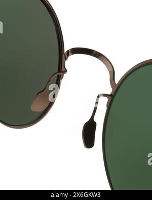 Detail of nose pad and bridge of round Panto shaped metal sunglasses with bronze frames and green lenses close up Stock Photo