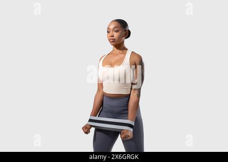 Confident Young Woman Posing in Athletic Wear Against Neutral Background Stock Photo