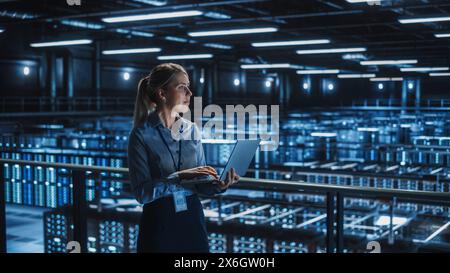 Data Center Female It Specialist Using Laptop. Server Farm Cloud Computing and Cyber Security Maintenance Administrator Working on Computer. Information Technology Professional. Stock Photo
