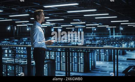 Data Center Engineer Using Digital Tablet Computer, Maintenance Specialist. High-Tech Information Protection, Cyber Security. Cloud Computing Facility. Server Farm for Iaas, saas, paas. Stock Photo