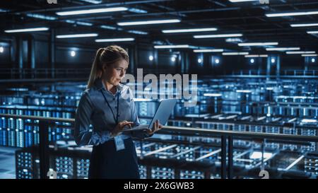Data Center Female It Specialist Using Laptop. Server Farm Cloud Computing and Cyber Security Maintenance Administrator Working on Computer. Information Technology Professional. Stock Photo
