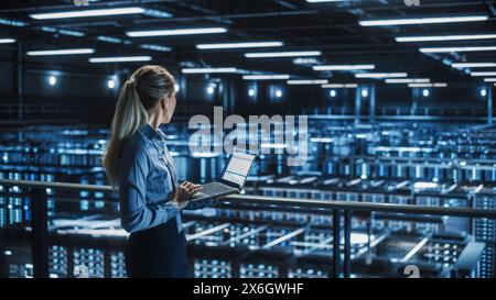 Data Center Female It Specialist Using Laptop. Server Farm Cloud Computing Facility with Beautiful Maintenance Administrator Working on Computer. Information Technology Professional. Stock Photo