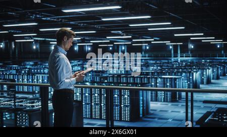 Data Center Engineer Using Digital Tablet Computer, Maintenance Specialist. High-Tech Information Protection, Cyber Security. Cloud Computing Facility. Server Farm for Iaas, saas, paas. Stock Photo