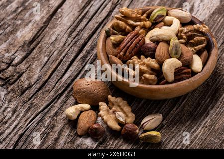variety of dried fruits in the bowl and on the old wooden table in extreme close-up. Stock Photo