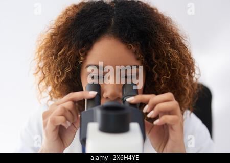 Female scientist, microscope and analyse in laboratory for innovation or medical breakthrough. Health, data and specialist with doctor in the Stock Photo