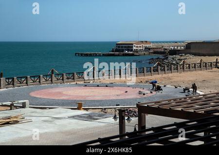 Workers setting interlocks in a circular pattern on the new public esplanade outside the new university in the old Luderitz power station. Stock Photo