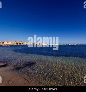 Italy, Sicily, Marzamemi (Siracusa province), fishing boats in the harbour and the old tuna fishing factory buildings Stock Photo