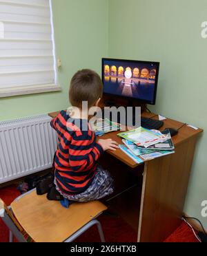 Computer room of the medrese. Little boy sitting in front a monitor of a computer. Islamic culture centre. October 21, 2018. Kiev, Ukraine Stock Photo