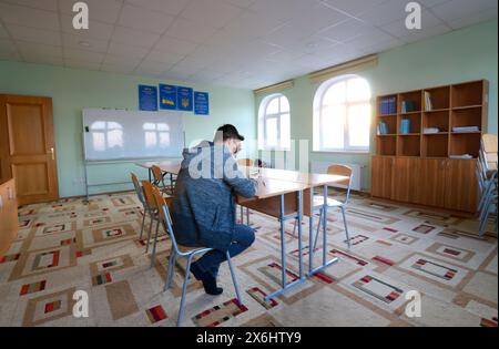 Reading-room of the medrese. Young man sitting at a desk, and reading book. October 21, 2018. Islamic culture centre, Kiev, Ukraine Stock Photo