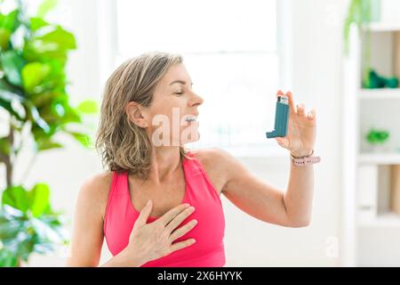 woman using asthma inhaler in white clinic Stock Photo
