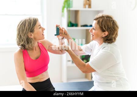 woman using asthma inhaler in white clinic Stock Photo