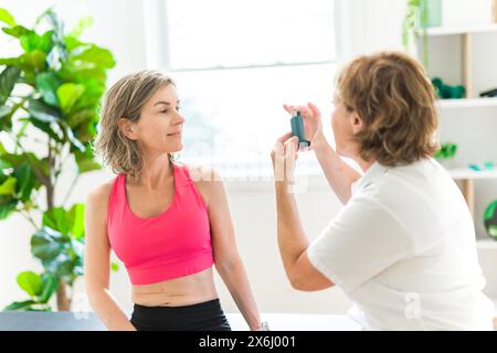 woman using asthma inhaler in white clinic Stock Photo