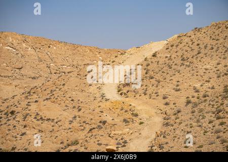 A winding path going up a hill in a desert on a clear, sunny day. Stock Photo