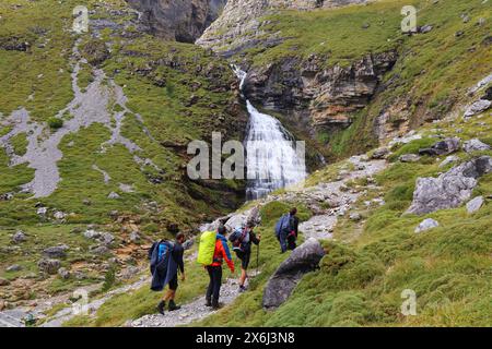 PYRENEES, SPAIN - SEPTEMBER 25, 2021: Tourists visit waterfall named Cascada de la Cola de Caballo in Ordesa y Monte Perdido National Park in Pyrenees Stock Photo