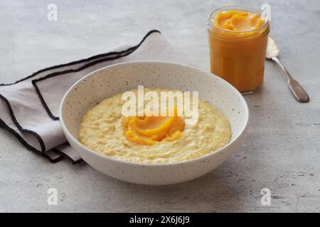 Bowl of oatmeal with pumpkin on a gray textured background. Delicious healthy homemade breakfast Stock Photo