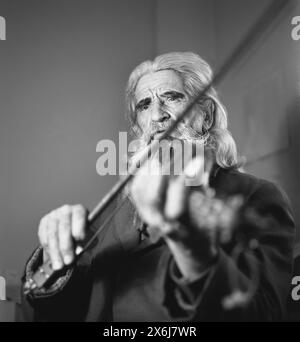 Romania, approx. 1974. Portrait of an elderly man playing the violin. Stock Photo