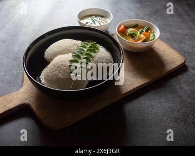 South Indian breakfast idli served in a bowl with condiments. Close up. Stock Photo