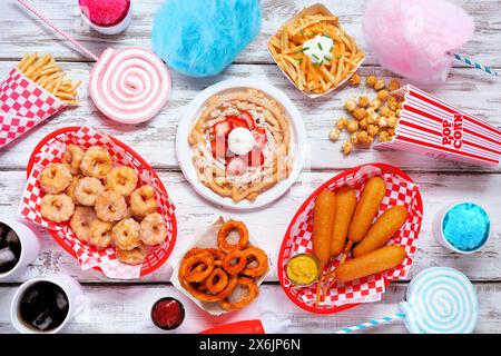 Carnival theme food double border over a white wood banner background. Overhead view with copy space. Summer fair concept. Corn dogs, funnel cake, cot Stock Photo