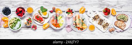 Healthy breakfast food table scene. Top down view over a white wood banner background. Omelette, nutritious bowl, toasts, granola bars, smoothie bowl, Stock Photo