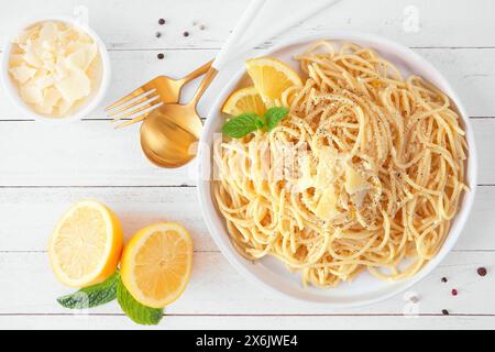 Spaghetti pasta with fresh lemon and parmesan cheese sauce. Top down view table scene on a white wood background. Stock Photo