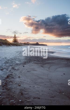 Deserted beach at sunset with dramatic clouds in the sky Stock Photo
