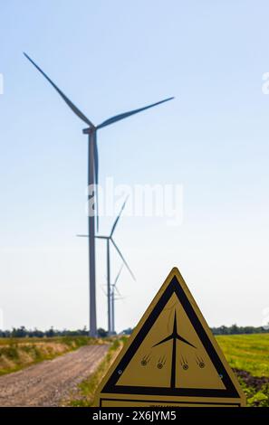Wind Turbines with a caution sign warning of the dangers of approaching the turbine. Stock Photo