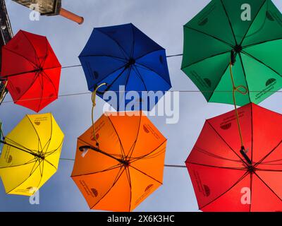 Bright colourful umbrellas hanging in the sky Stock Photo