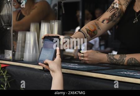 Payment by tap and go, customer using smartphone payment for purchase Stock Photo