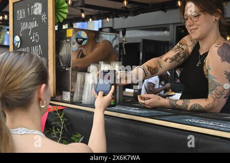 Payment by tap and go, customer using smartphone payment for purchase Stock Photo