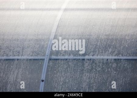 Industrial background photo. Greenhouse wall made of transparent polycarbonate sheets mounted on metal framework Stock Photo