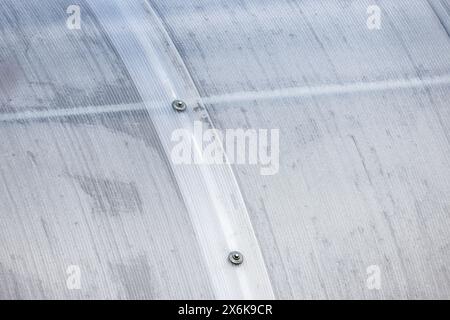 Greenhouse wall made of transparent polycarbonate sheets mounted on metal framework, background photo texture Stock Photo