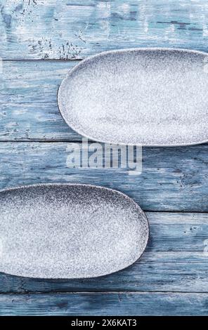 Two empty oval plates on old rustic wooden table. Top view, with copy space Stock Photo
