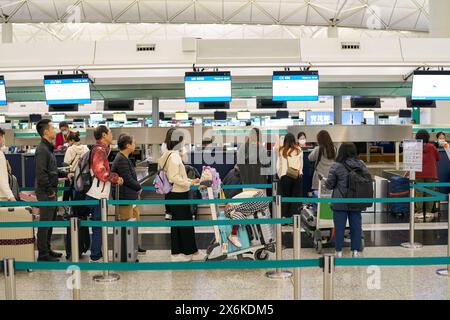 HONG KONG, CHINA - DECEMBER 04, 2023: passengers waiting in line at check-in area in Hong Kong International Airport. Stock Photo