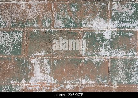 green white and brown chipped old painted cinder block wall background Stock Photo