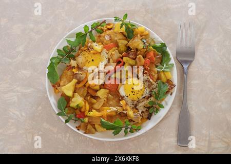 a plate of fried quail eggs and vegetables on hash browns with fresh arugula leaves Stock Photo