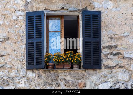 Shuttered window with flower box Stock Photo
