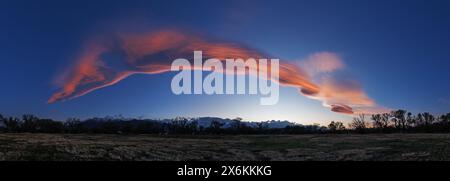 Sierra wave cloud formed by high winds blowing over the mountains at sunset over Bishop California Stock Photo