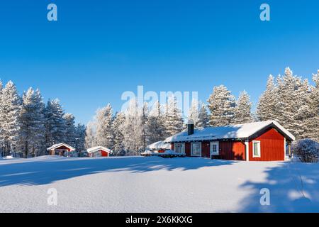 red Swedish house in winter landscape; Råneå, Norrbotten, Sweden Stock Photo