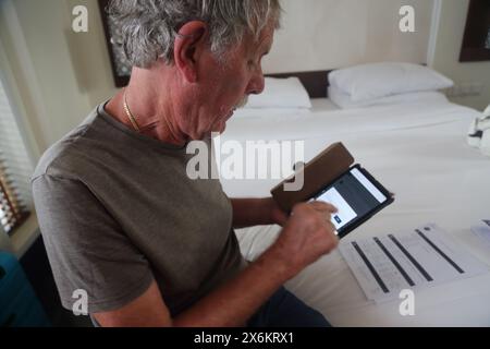 Man Checking in on Flight using iPad at The Chedi Hotel Muscat Oman Stock Photo