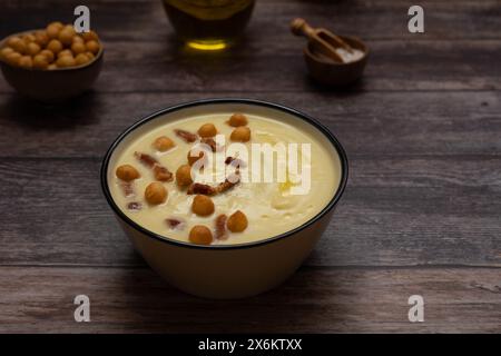 Creamy white asparagus soup bowl sits on a warm wood background Stock Photo