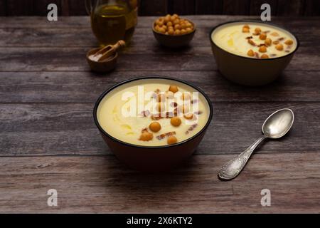 Creamy white asparagus soup bowls that sit on a warm wood background Stock Photo
