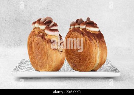 Supreme croissants with chocolate chips and cream on grey background, closeup. Tasty puff pastry Stock Photo