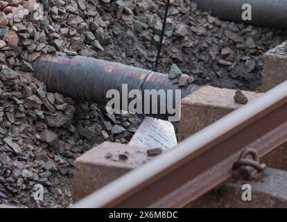 Rail Accident investigation branch tag on  water pipe damaged by a tamping machine at the site of the train derailment at Grange Over Sands March 2024 Stock Photo