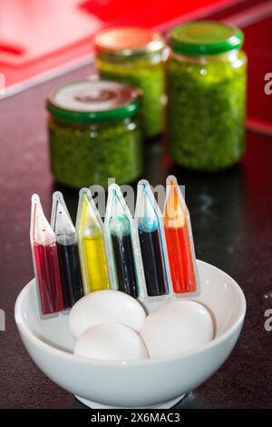 Easter egg colours and white eggs in front of jars of wild garlic pesto Stock Photo
