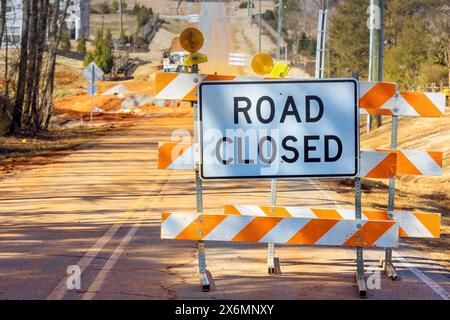 Sign indicating that road is closed with orange stripes near construction site that is preventing vehicles from driving Stock Photo